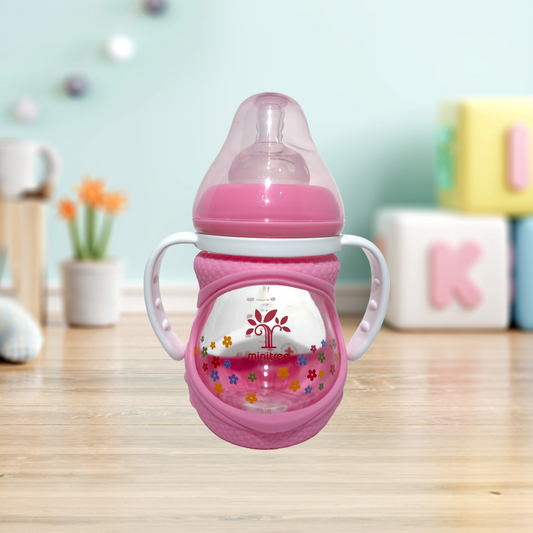 Discover the Minitree Wide Neck Glass Baby Feeder with Handles, perfect for babies 3 months and up. This 160ml feeder, crafted from 0% BPA materials, ensures a safe and healthy feeding experience. Featuring a cute floral print, wide neck for easy cleaning, and ergonomic handles for comfortable grip, it combines practicality, safety, and style. Available now on Babyfairy.pk. Make feeding time delightful and hassle-free!